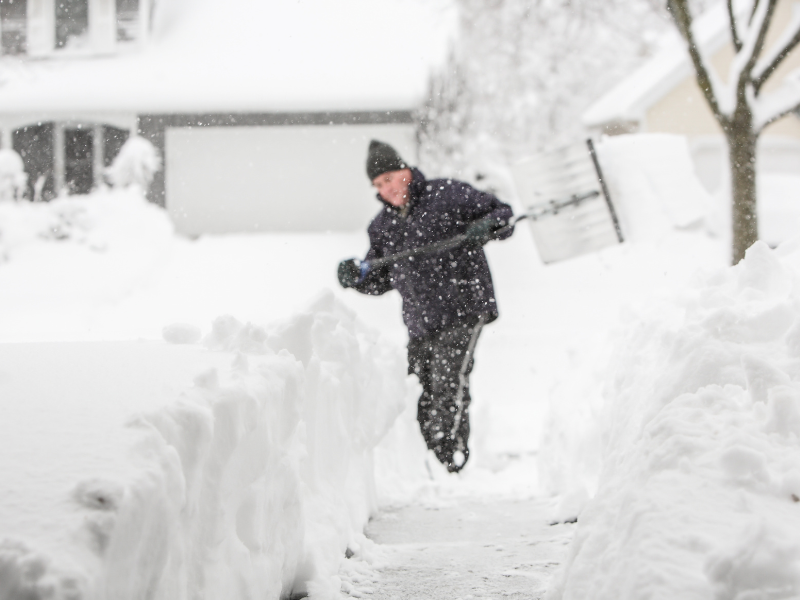 An Edmonton homeowner shovelling their driveway in the winter.