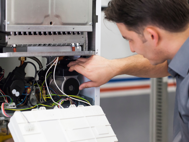 A licensed Habberjam At Home technician performing furnace maintenance.