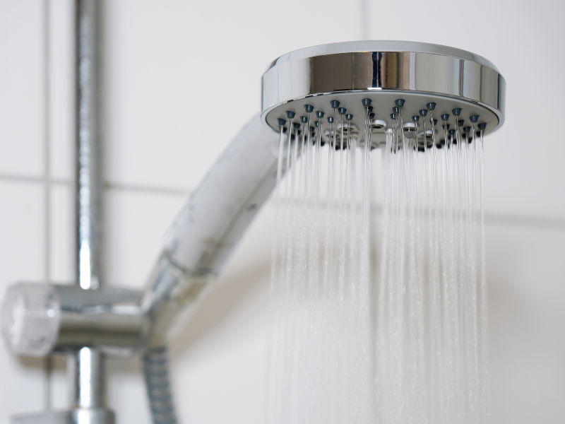 Low-flow showerhead installed in a modern bathroom. Water-Saving Tips: How to Conserve Water with Smart Plumbing