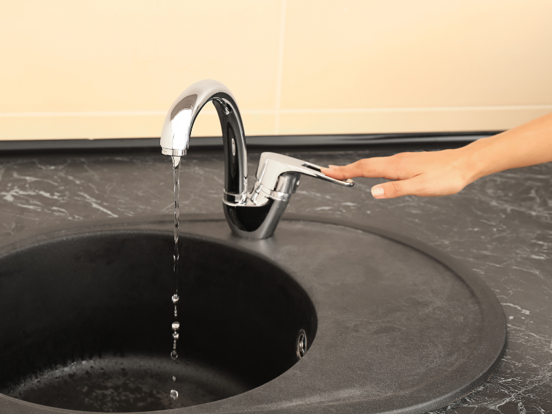 An Edmonton homeowner turning off a water tap to conserve water while brushing. Water-Saving Tips: How to Conserve Water with Smart Plumbing.