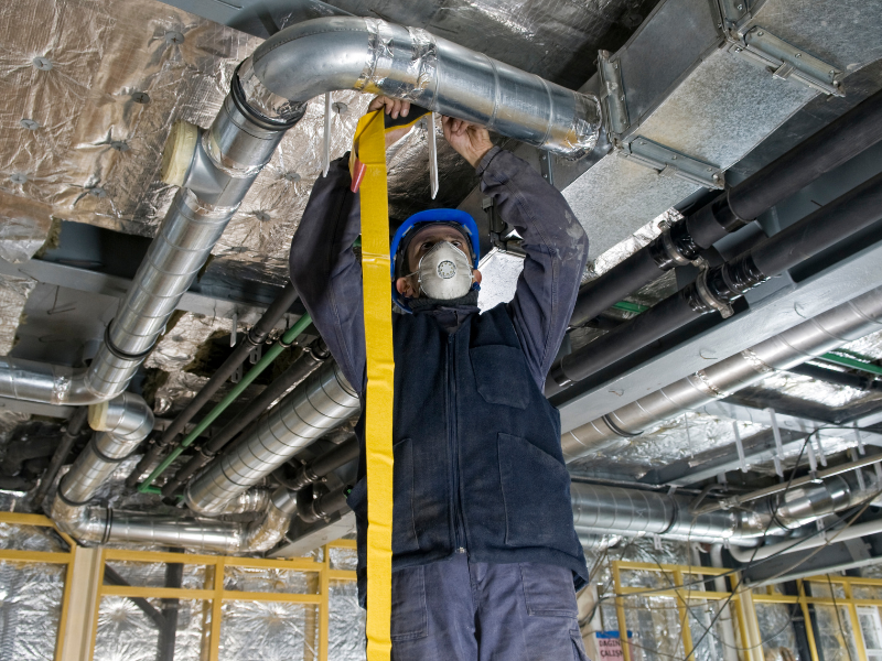 HVAC technician inspecting the ductwork for leaks. A complete HVAC system maintenance checklist.