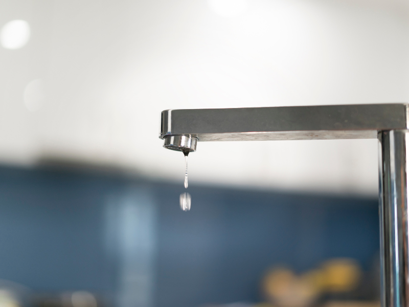 A kitchen faucet dripping water.