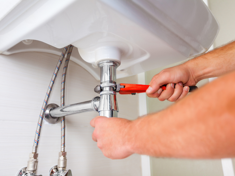 A plumber performing a routine inspection on a home's water pipes to prevent leaks and improve efficiency. Stay Ahead of Home Maintenance: Key HVAC & Plumbing Challenges to Tackle in 2025.